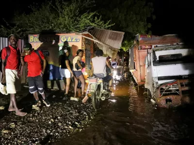 People walk along a street after floods caused by the outer bands of Hurricane Melissa killed several people, in Petit Goave, Haiti, October 29, 2025. REUTERS/Egeder Pq Fildor