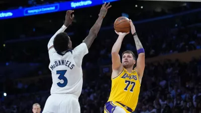 Oct 24, 2025; Los Angeles, California, USA; Los Angeles Lakers guard Luka Doncic (77) shoots the ball against Minnesota Timberwolves forward Jaden McDaniels (3) in the second half at Crypto.com Arena. Mandatory Credit: Kirby Lee-Imagn Images