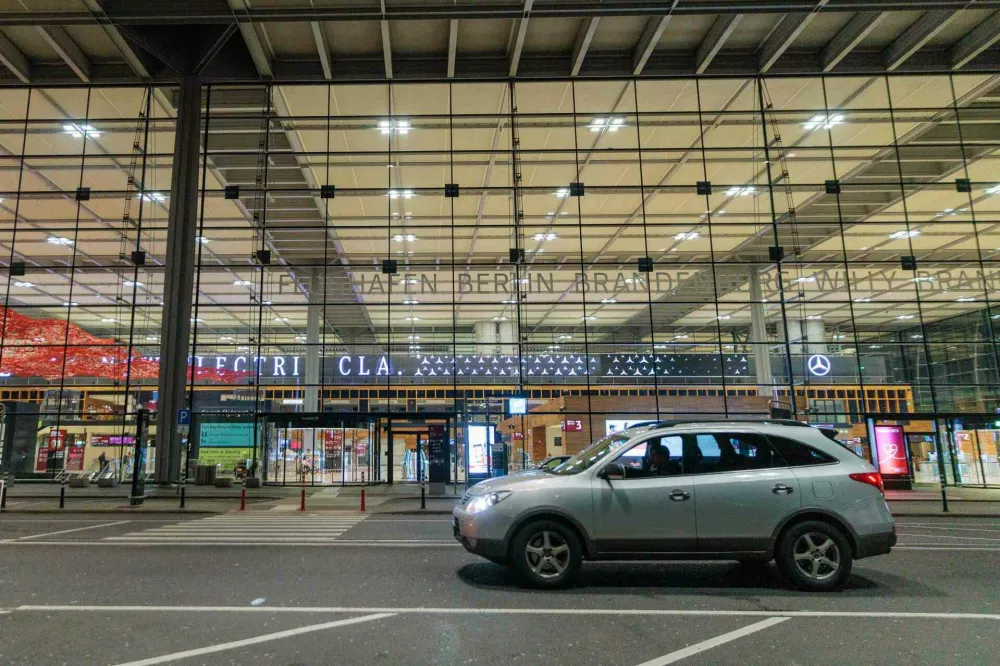 A car sits outside Berlin Brandenburg Airport after it was closed earlier in the evening due to a drone sighting, Friday, Oct. 31, 2025, in Schönefeld, Germany. (Carsten Koall/dpa via AP)