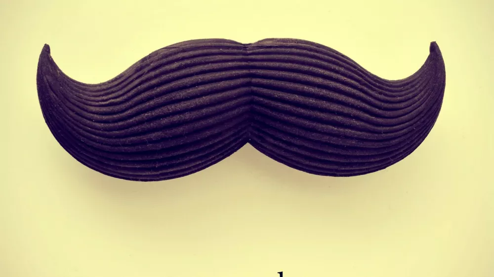 the word movember and a mustache on a beige background with a retro effect