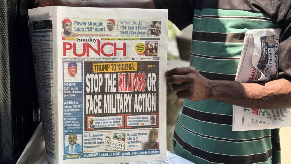 A vendor sells local newspapers with headlines referring to US President Donald Trump's comments about Nigeria, on the street of Lagos, Nigeria, Sunday, Nov. 2, 2025. (AP Photo/Sunday Alamba)