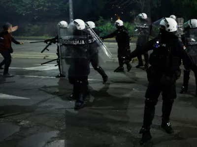 Serbian riot police separate rival crowds of opponents, right, and loyalists of autocratic President Aleksandar Vucic, a day after tens of thousands of people joined a huge rally in the northern city of Novi Sad marking the first anniversary of a train station disaster there that killed 16 people, in Belgrade, Serbia, Sunday, Nov. 2, 2025. (AP Photo/Marko Drobnjakovic)