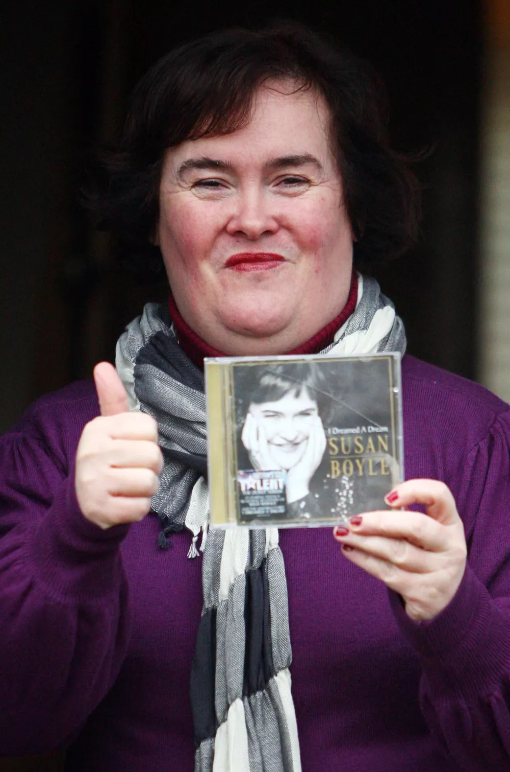 ** ADDS LATER INFORMATION ** British singer Susan Boyle displays a copy of her CD, at the front door of her house in Blackburn, Scotland, Saturday Nov. 28, 2009. Susan Boyle's debut record, "I Dreamed A Dream," entered the British album chart in the top spot Sunday. (AP Photo/Andrew Milligan, PA) ** UNITED KINGDOM OUT NO SALES NO ARCHIVE **