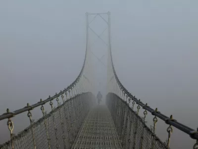 A woman walks on a suspension bridge, during a foggy morning, in Lalitpur, Nepal, November 6, 2025. REUTERS/Navesh Chitrakar   TPX IMAGES OF THE DAY / Foto: Navesh Chitrakar