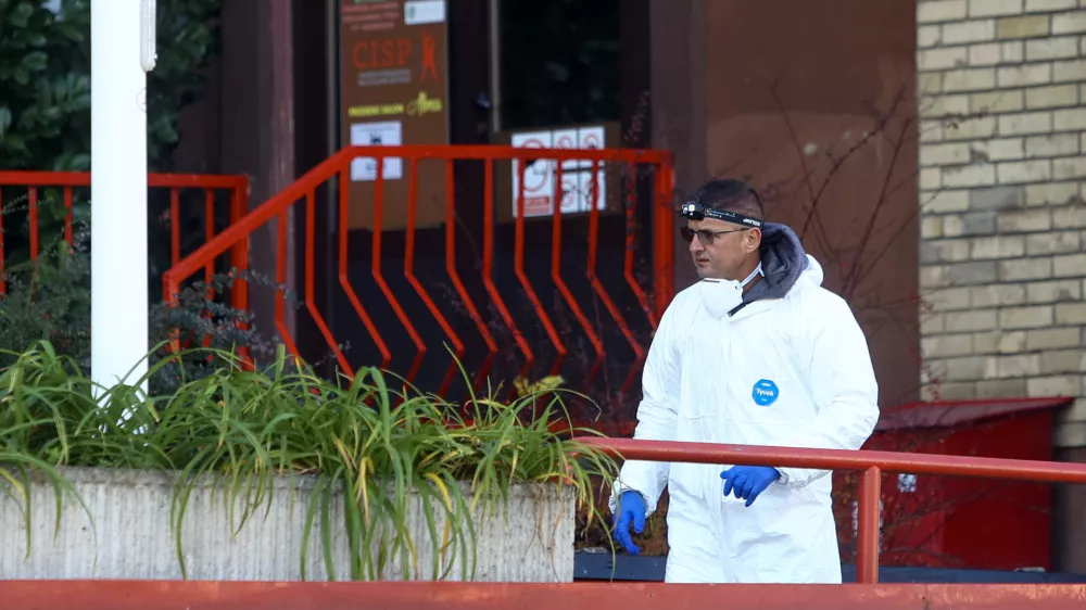 A forensic policeman stands in front of a retirement home following a major fire that killed at least 11 people, in Tuzla, Bosnia, Tuesday, Nov. 5, 2025. (AP Photo)