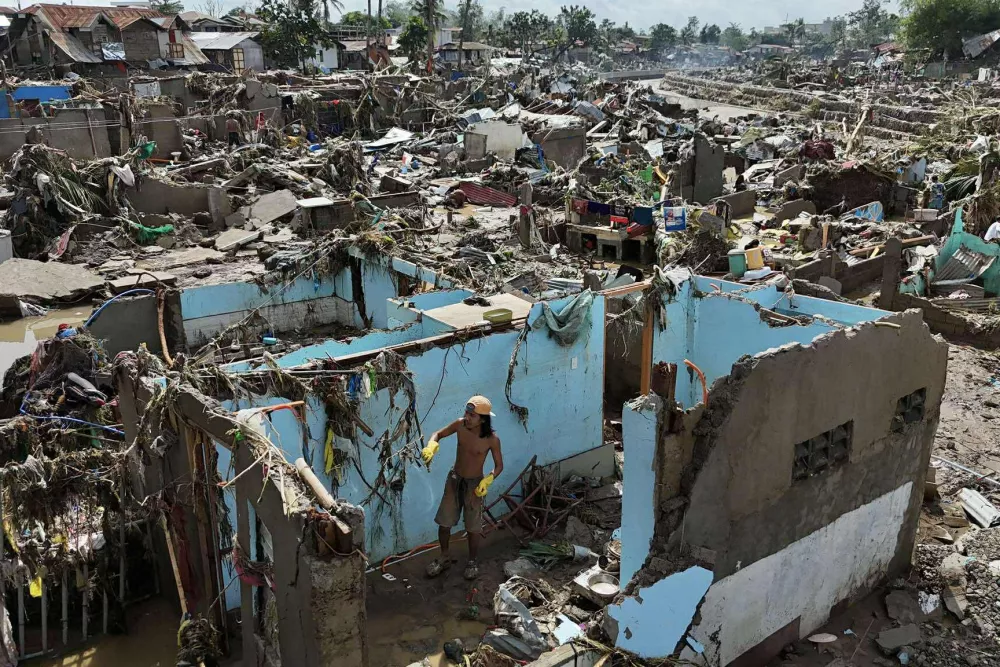 FILE - A resident returns to what remains of a home in the aftermath of Typhoon Kalmaegi that devastated communities along the Mananga River in Talisay, Philippines, Nov. 5, 2025. (AP Photo/Jacqueline Hernandez, File)
