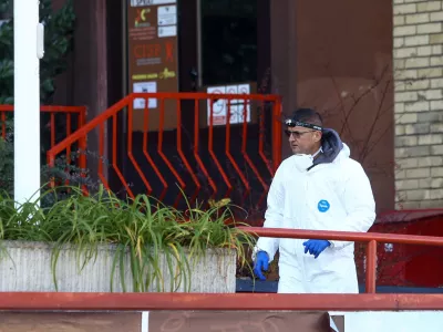 A forensic policeman stands in front of a retirement home following a major fire that killed at least 11 people, in Tuzla, Bosnia, Tuesday, Nov. 5, 2025. (AP Photo)