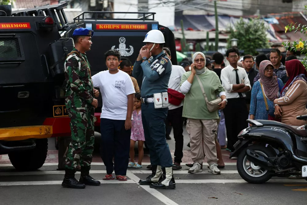Indonesian military personnel guard as residents gather near the area after an explosion occurred at a school complex in Jakarta, Indonesia, November 7, 2025. REUTERS/Willy Kurniawan