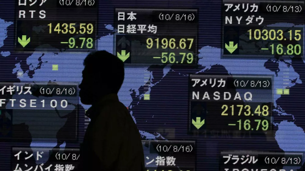 A pedestrian is silhouetted in front of an electronic board displaying stock price index of Japan (C) and other countries outside a brokerage in Tokyo August 16, 2010. The yen rose broadly on Monday as high-yielding currencies and Asian equities faltered, with talk of possible demand from Japanese exporters and investor fund repatriation also giving the yen a boost. REUTERS/Yuriko Nakao (JAPAN - Tags: BUSINESS EMPLOYMENT)