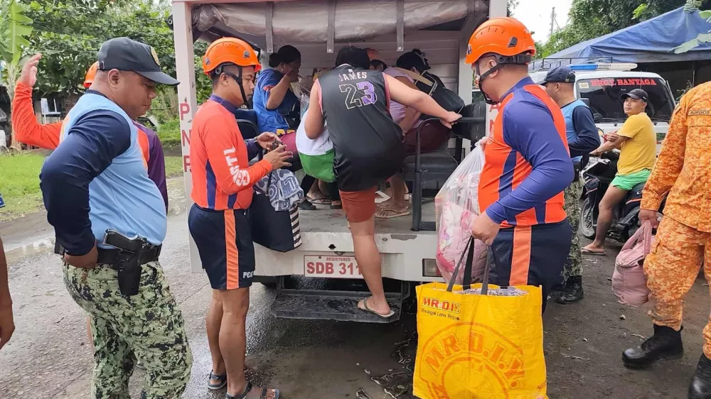 In this photo provided by the Philippine Coast Guard, rescuers evacuate people to safer grounds in Quezon province, eastern Philippines as Typhoon Fung-wong enters the country on Sunday Nov. 9 2025. (Philippine Coast Guard via AP)