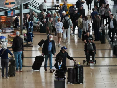 People make their way through a terminal at San Diego International Airport Saturday, Nov. 8, 2025, in San Diego. (AP Photo/Gregory Bull)