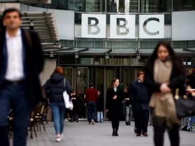 ﻿FILE PHOTO: Pedestrians walk past a BBC logo at Broadcasting House in London, Britain, January 29, 2020. REUTERS/Henry Nicholls/File Photo