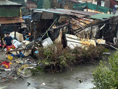 A man checks a damaged house due to Typhoon Fung-wong along a coastal village on Monday, Nov. 10, 2025, in Navotas, Philippines. (AP Photo/Aaron Favila)