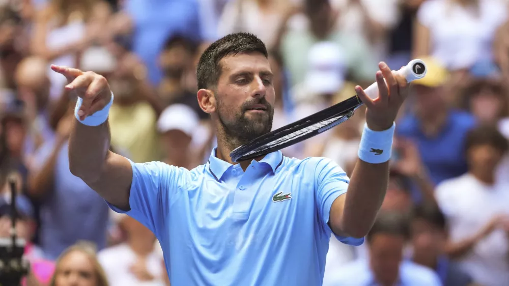 Novak Djokovic, of Serbia, pretends to play the violin after defeating Zachary Svajda, of the United States, during the second round of the U.S. Open tennis championships, Wednesday, Aug. 27, 2025, in New York. (AP Photo/Kirsty Wigglesworth)