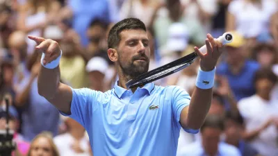 Novak Djokovic, of Serbia, pretends to play the violin after defeating Zachary Svajda, of the United States, during the second round of the U.S. Open tennis championships, Wednesday, Aug. 27, 2025, in New York. (AP Photo/Kirsty Wigglesworth)