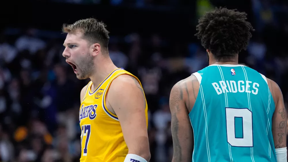 Los Angeles Lakers guard Luka Doncic celebrates after scoring as Charlotte Hornets forward Miles Bridges looks on during the second half of an NBA basketball game Monday, Nov. 10, 2025, in Charlotte, N.C. (AP Photo/Chris Carlson)