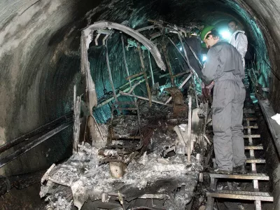 ** FILE ** In this Thursday, Nov. 16, 2000 file photo, a worker looks at a burnt cable car inside a tunnel in the Kitzsteinhorn mountain in Kaprun, Austria, where 155 people died in a fire. Nearly eight years after skiers and snowboarders died in Austria's Alps, a compensation commission has announced on Tuesday, June 17, 2008, that 451 claimants will share euro 13.9 million (US$ 21.5 million) in damages stemming from Austria's worst peacetime disaster. (AP Photo/Franz Neumayr, Pool, File)