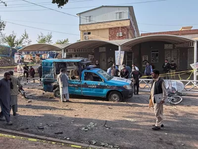 Security officials examine a damage vehicle at the site following a suicide bombing outside the gates of a district court, in Islamabad, Pakistan, Tuesday, Nov. 11, 2025. (AP Photo/Mohammad Yousuf)