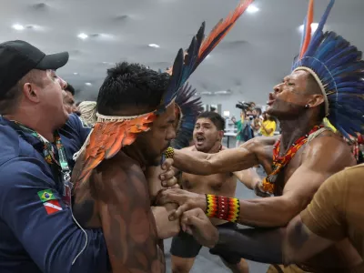 An Indigenous demonstrator is held by a staff member as protesters force their way into the venue hosting the UN Climate Change Conference (COP30), in Belem, Brazil, November 11, 2025. REUTERS/Anderson Coelho   TPX IMAGES OF THE DAY
