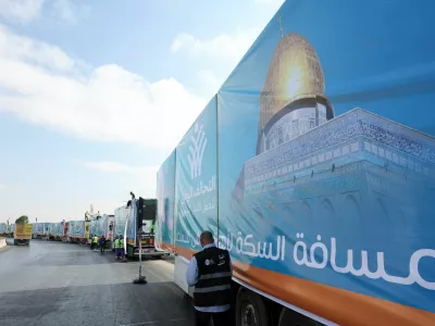 A man walks next to trucks loaded with humanitarian aid from Egypt's National Alliance For Civil Development Work (NACDW) as they are on their way to the Rafah border crossing to enter Gaza, after a ceasefire between Israel and Hamas in Gaza went into effect, on the Cairo-Ismailia desert road, in Egypt, October 16, 2025. REUTERS/Amr Abdallah Dalsh