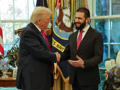 In this photo released by Syrian Presidency press office, President Donald Trump, left, shakes hands with Syria's President Ahmad al-Sharaa, at the White House in Washington, Monday, Nov. 10, 2025. (Syrian Presidency press office via AP)