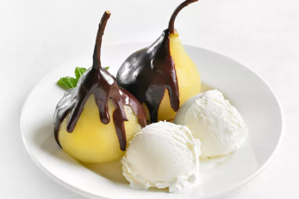 Poached pears with chocolate sauce and ice cream on white background. Close up view / Foto: Tatiana Volgutova