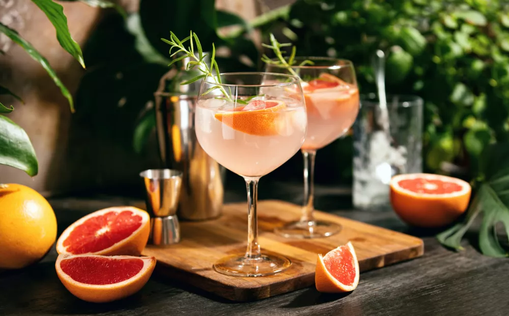 Pink grapefruit and rosemary gin cocktail served in prepared gin cocktail glass on a tropical beach bar / Foto: Fortyforks