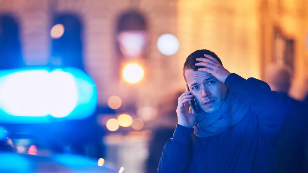 Young man calling after a crisis situation on city street. Themes crime, emergency medical service, fear or help. / Foto: Chalabala