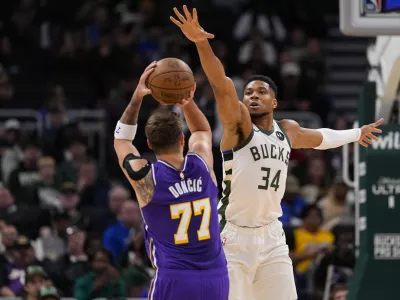 Nov 15, 2025; Milwaukee, Wisconsin, USA; Milwaukee Bucks forward Giannis Antetokounmpo (34) defends Los Angeles Lakers guard Luka Doncic (77) during the first quarter at Fiserv Forum. Mandatory Credit: Jeff Hanisch-Imagn Images