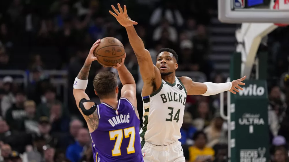 Nov 15, 2025; Milwaukee, Wisconsin, USA; Milwaukee Bucks forward Giannis Antetokounmpo (34) defends Los Angeles Lakers guard Luka Doncic (77) during the first quarter at Fiserv Forum. Mandatory Credit: Jeff Hanisch-Imagn Images