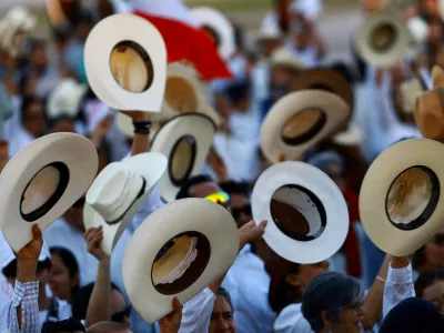 Protesters raise their hats during a demonstration against insecurity and corruption in the country, as well as over the recent killing of Uruapan mayor Carlos Manzo, in Ciudad Juarez, Mexico, November 15, 2025. REUTERS/Jose Luis Gonzalez   TPX IMAGES OF THE DAY