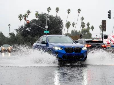 A vehicle crosses a flooded roadway in Pasadena, Calif., on Saturday, Nov. 15, 2025. (AP Photo/Noah Berger)