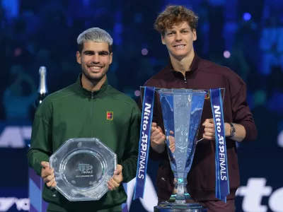 Spain's Carlos Alcaraz, left, and winner Italy's Jannik Sinner stand on the podium after the final tennis match of the ATP World Tour Finals, in Turin, Italy, Sunday, Nov. 16, 2025. (AP Photo/Antonio Calanni)