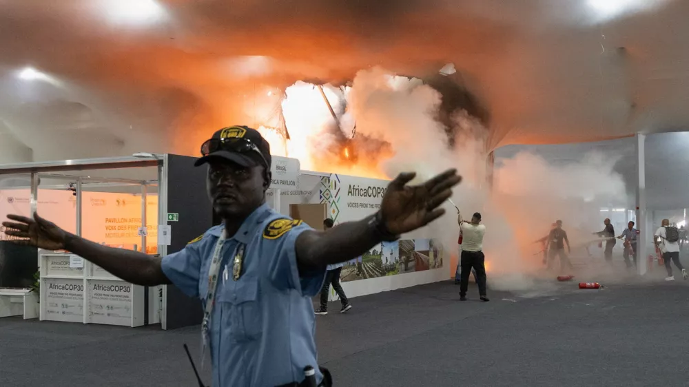A security guard gestures as people use fire extinguishers to put out a fire at the Pavilion of Countries in the Blue Zone at the United Nations Climate Change Conference (COP30) in Belem, Brazil, November 20, 2025. REUTERS/Douglas Pingituro
