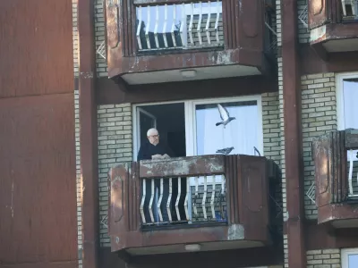 A man at an elderly people's home feeds pigeons, in an undamaged part of the building after a fire at the elderly people's home, in the town of Tuzla, Bosnia and Herzegovina, November 5, 2025. REUTERS/Amel Emric