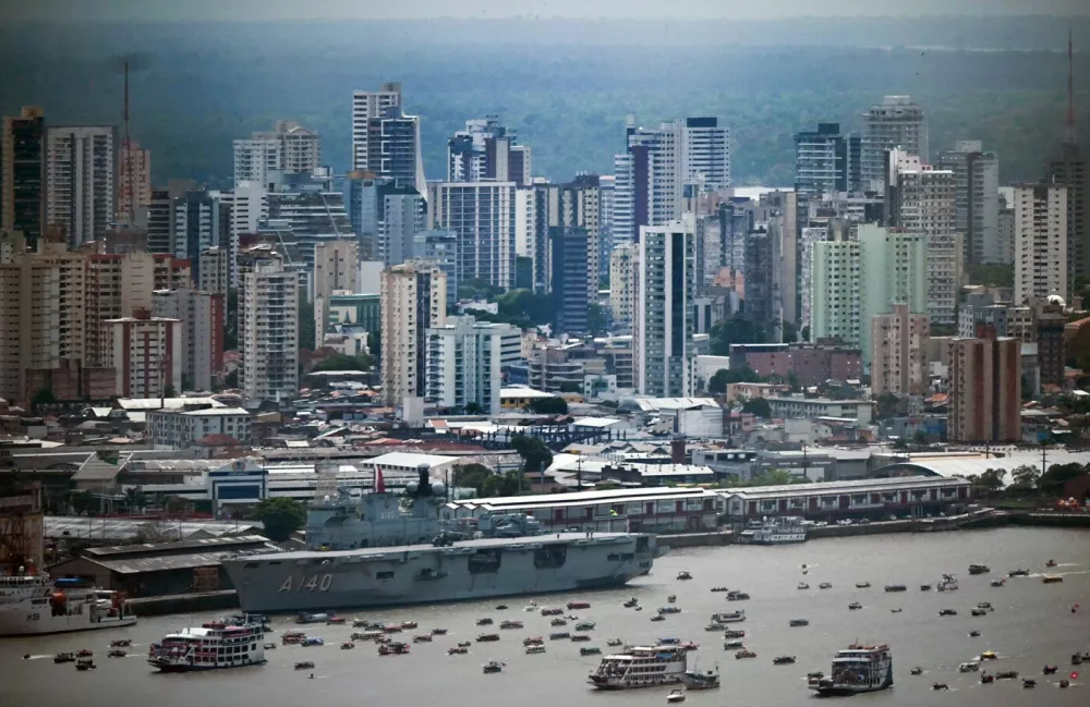 View of boats of indigenous people and social organizations sailing together in the sidelines of the COP30 UN Climate Change Conference with the city center of Belem in the background in Belem, Para State, Brazil, on November 12, 2025. Over 150 boats with members of indigenous communities and social organizations sailed the Guama River as part of a symbolic crossing during the COP30, according to organizers.,Image: 1052029409, License: Rights-managed, Restrictions:, Model Release: no