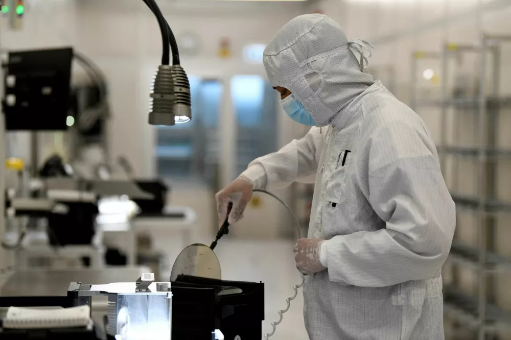 FILE PHOTO: An employee works with a wafer in a production line of Dutch semiconductor company Nexperia, in Hamburg, Germany, June 27, 2024. REUTERS/Fabian Bimmer/File Photo
