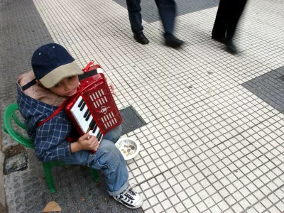 A child identified as Belusa plays acordion trying to get some coins in Buenos Aires, Tuesday, May 20, 2003.. Many question whether Nestor Kirchner, Argentina's next president, can quickly raise living standards in a country where one in five doesn't have a job and 60 percent live below the poverty level. (AP Photo/Natacha Pisarenko)