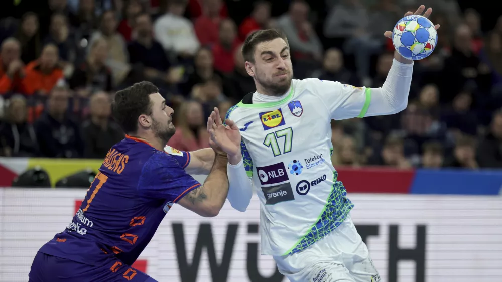 Slovenia's Nejc Cehte and Dani Baijens from the Netherlands, left, in action during the Handball European Championship main round, group 2 match between Slovenia and Netherlands in Hamburg, Germany, Sunday Jan. 21, 2024. (Christian Charisius/dpa via AP)
