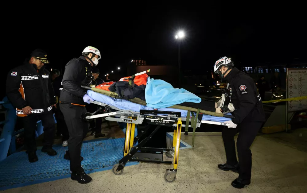 Rescue workers move a passenger rescued from a stranded South Korean ferry carrying about 260 people near a rocky island off Shinan, in Mokpo, South Korea, November 19, 2025.  Yonhap via REUTERS  ATTENTION EDITORS - THIS IMAGE HAS BEEN SUPPLIED BY A THIRD PARTY. SOUTH KOREA OUT. NO RESALES. NO ARCHIVE.