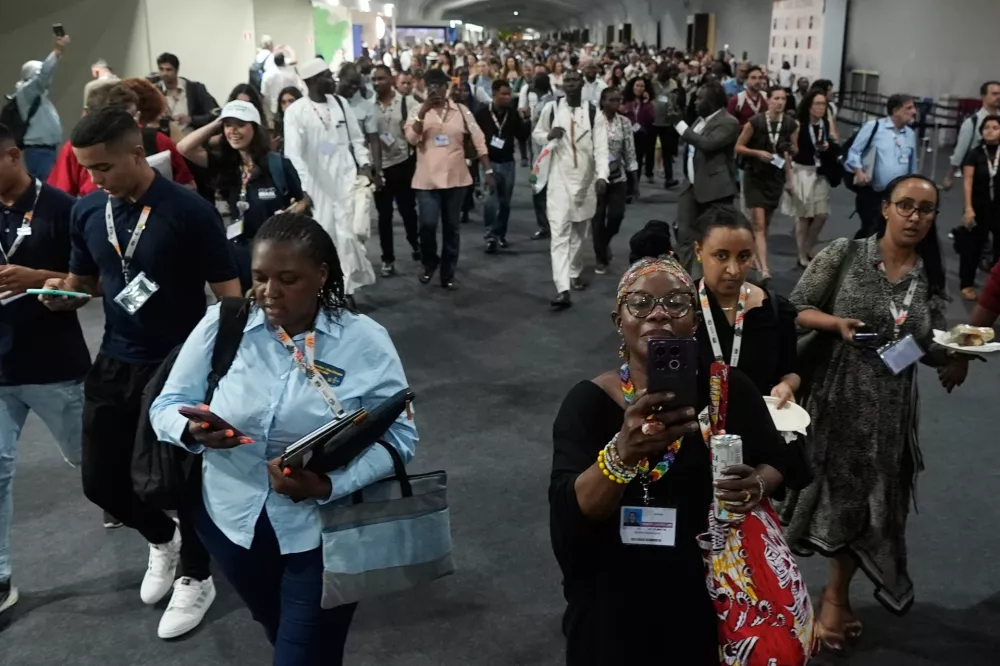 Attendees exit the venue for the COP30 U.N. Climate Summit after a fire was reported, Thursday, Nov. 20, 2025, in Belem, Brazil. (AP Photo/Fernando Llano)