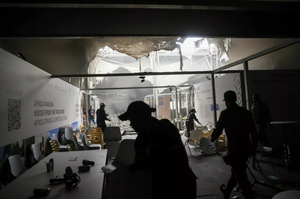 People walk inside a damaged pavillion following a fire alert during the UN Climate Change Conference (COP30), in Belem, Brazil, November 20, 2025. REUTERS/Adriano Machado