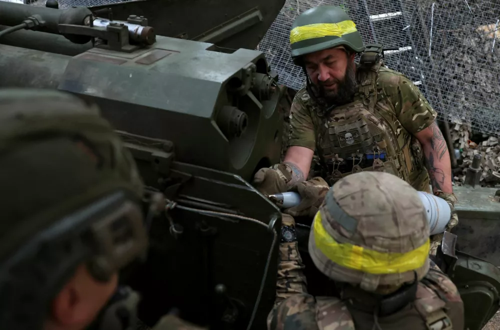 Service members of the 15th 'Kara-Dag' Brigade of the Operational Assignment of the National Guard of Ukraine load ammunition into a 2A36 Giatsint-B howitzer as they fire it towards Russian troops, at a position on a front line near the town of Kupiansk, amid Russia's attack on Ukraine, in Kharkiv region, Ukraine May 27, 2025. REUTERS/Anatolii Stepanov