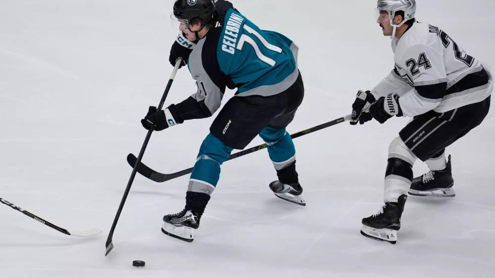 San Jose Sharks center Macklin Celebrini (71) passes the puck while defended by Los Angeles Kings center Phillip Danault (24) during the second period of an NHL hockey game, Thursday, Nov. 20, 2025, in San Jose, Calif. (AP Photo/Godofredo A. Vásquez)