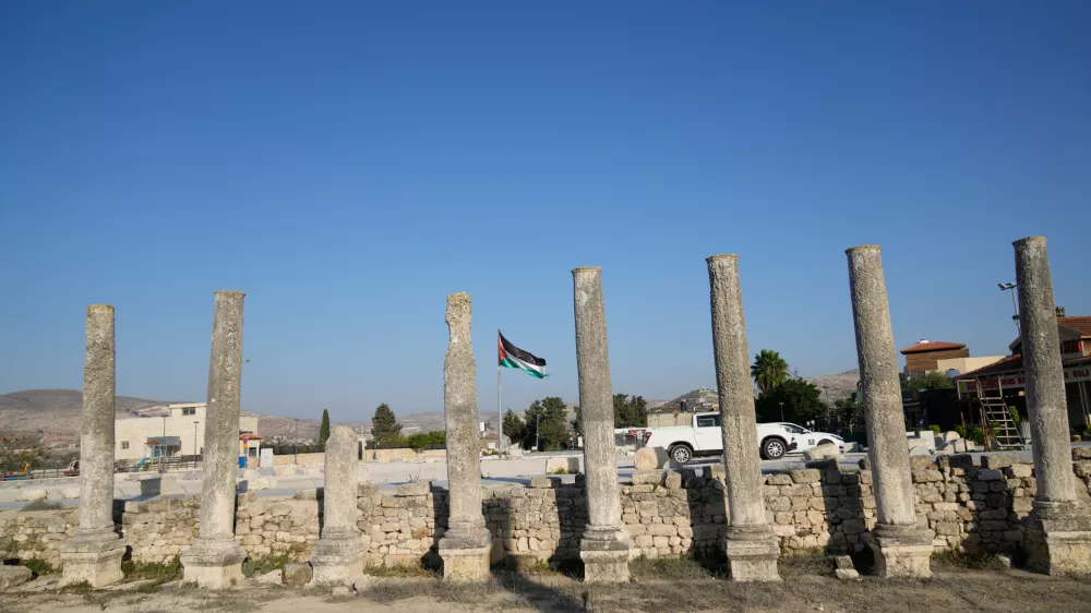 A Palestinian flag flies over the Roman historical site in the West Bank town of Sebastia Thursday, Nov. 20, 2025. (AP Photo/Nasser Nasser)