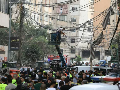Civil defence members work as people gather near the site of an Israeli strike, after Israeli military said on Sunday that it struck a militant from the Lebanese Iran-aligned Hezbollah group, in Beirut's southern suburbs, Lebanon November 23, 2025. REUTERS/Mohamed Azakir