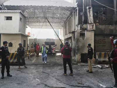 Security officials examine the site of a suicide bombing attack at the main gate of headquarters of the Federal Constabulary (FC), in Peshawar, Pakistan, Monday, Nov. 24, 2025. (AP Photo/Muhammad Zubair)