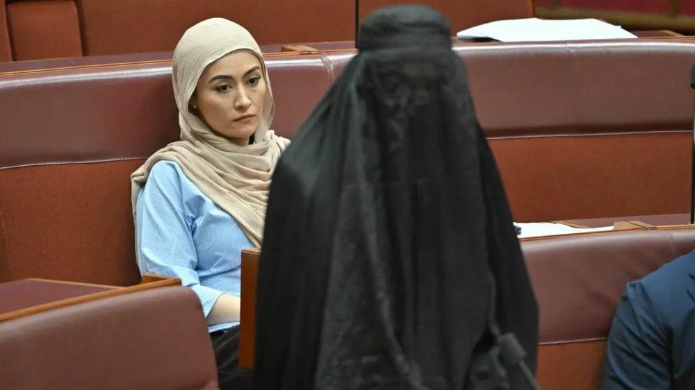 Independent senator Fatima Payman reacts as One Nation leader Pauline Hanson wears a burqa in the Senate chamber at Parliament House in Canberra, Australia, November 24, 2025. AAP/Mick Tsikas via REUTERS  ATTENTION EDITORS - THIS IMAGE WAS PROVIDED BY A THIRD PARTY. NO RESALES. NO ARCHIVE. AUSTRALIA OUT. NEW ZEALAND OUT. NO COMMERCIAL OR EDITORIAL SALES IN NEW ZEALAND. NO COMMERCIAL OR EDITORIAL SALES IN AUSTRALIA.