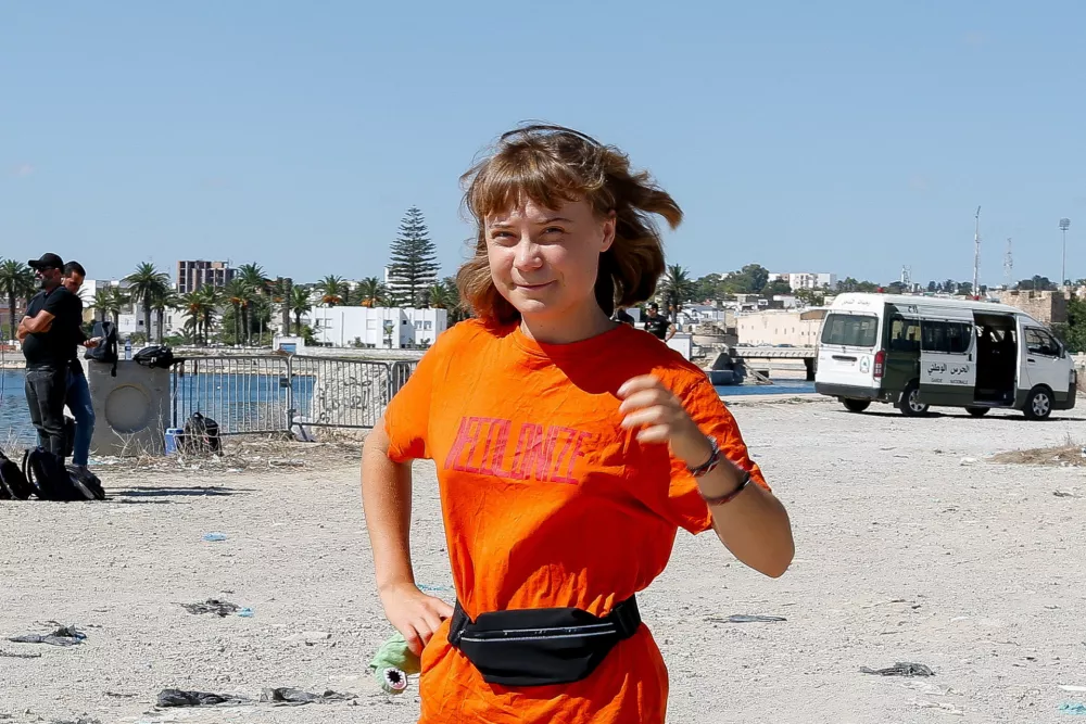 Swedish activist Greta Thunberg, a member of the Global Sumud Flotilla, walks as the flotilla waits to set sail towards Gaza, with other boats from Tunisia, as part of an international humanitarian aid initiative to break Israel's naval blockade and deliver vital supplies to Palestinians, at the port of Bizerte, Tunisia September 13, 2025. REUTERS/Zoubeir Souissi   TPX IMAGES OF THE DAY