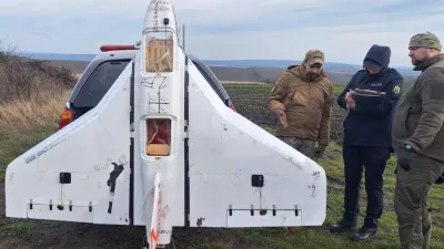 This image released by Moldova's Police on Tuesday, Nov. 25, 2025, police officers inspect a drone in the village of Cuhurestii de Jos, northern Moldova. (Moldova Police via AP)